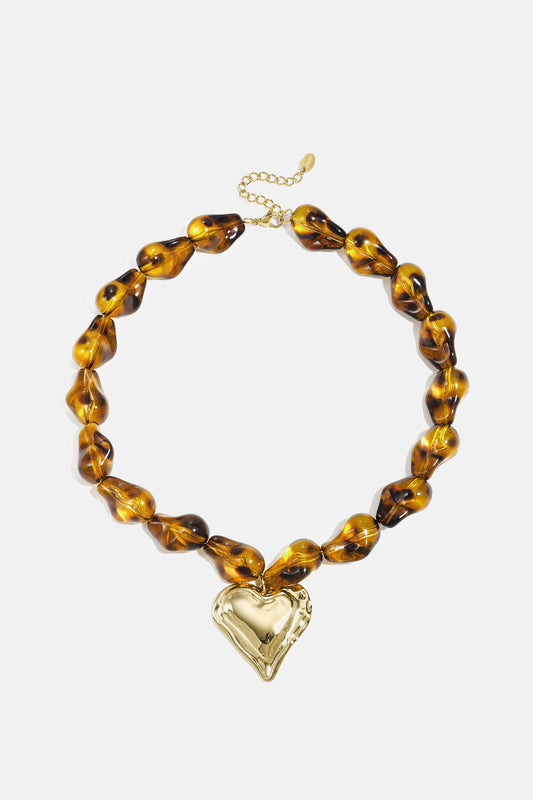 Collar con cuentas de forma natural y un corazón colgante.