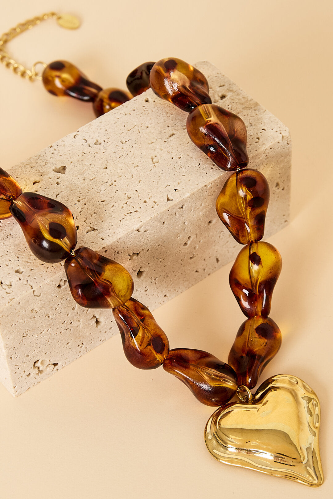 Collar con cuentas de forma natural y un corazón colgante.
