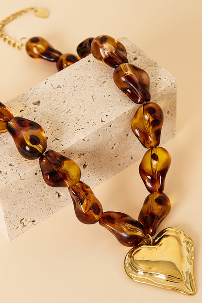 Collar con cuentas de forma natural y un corazón colgante.